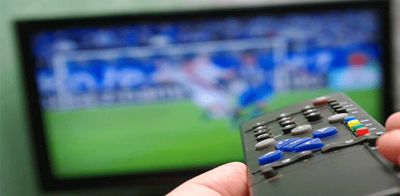 Viewer Holding Remote Control Watching Soccer On Connected-TV